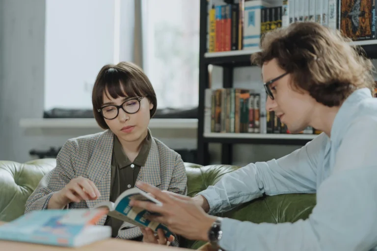 a woman and a man studyin in a library