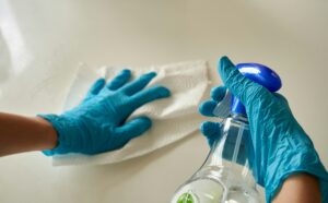 wiping a surface with cleaning supplies